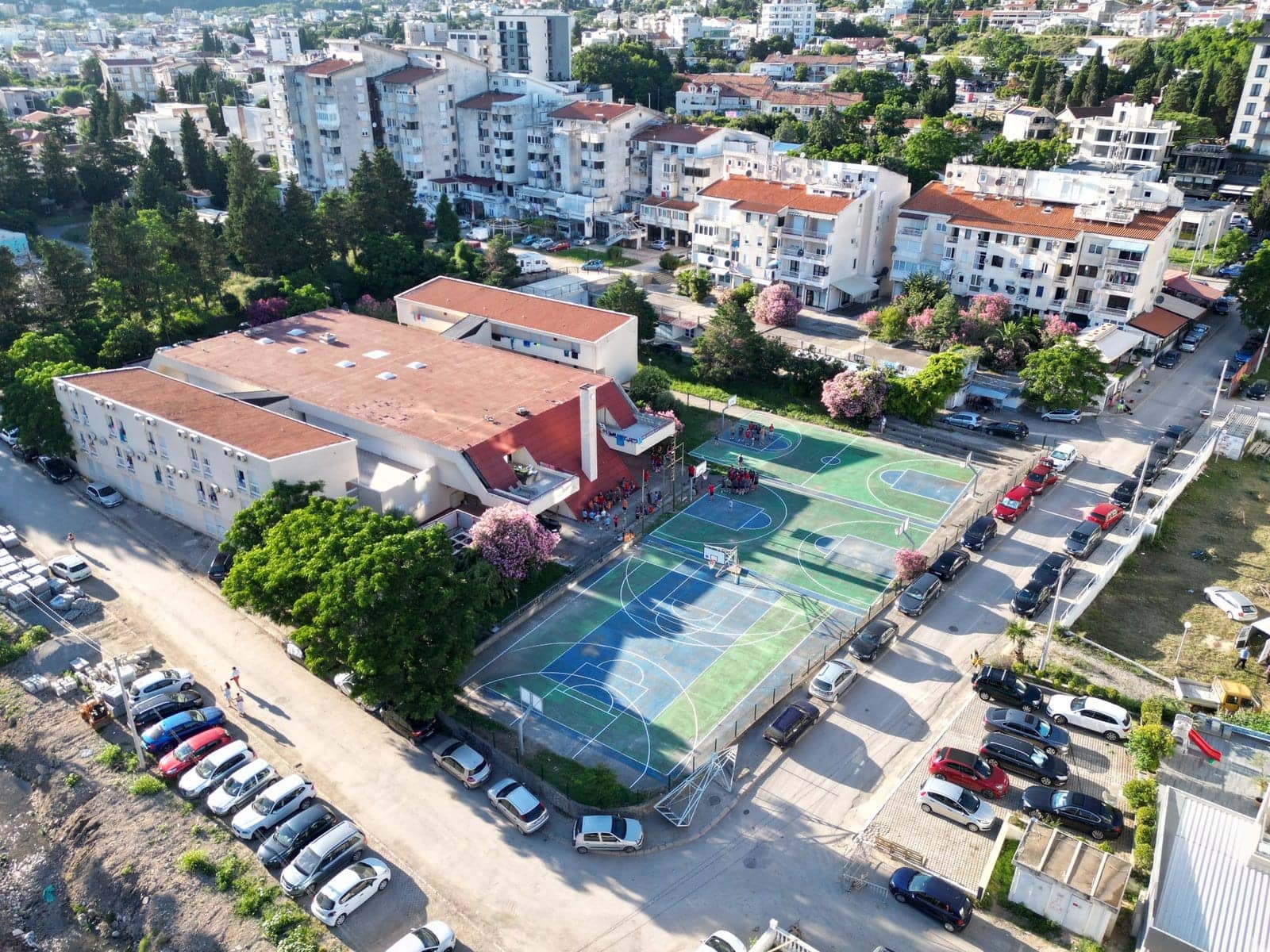 Pogled iz vazduha na kamp — smještaj uz dva košarkaška terena, grad Sutomore i more u pozadini